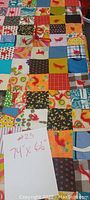 Photo of colorful patchwork quilt showing various fabric squares and red yarn knots with a note indicating size as 74 x 66 inches.