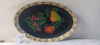 Oval wood fruit platter with painted fruits and decorative border, showing colors and style.