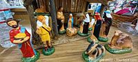 View of nativity set figurines including shepherds, Three Wise Men, and animals arranged in front of barn
