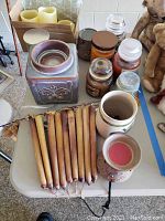 Overview photo of various candles including taper candles, jar candles, battery operated candles, and wax warmers on a table.