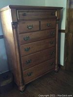Full frontal view of six drawer wooden dresser showing size, wood grain finish and drawer layout with metal pulls.
