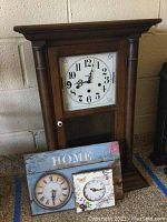 Vintage-style Howard Miller wooden clock with white dial and black numbers.