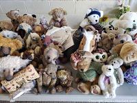 Various plush animals arranged on table includes owls, bears, horses
