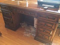 Front view of the Sligh wooden desk showing multiple drawers and fold down keyboard tray space.