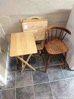 Photo showing the four wooden folding TV tray tables stacked and one wooden chair