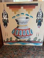Santa Fe style sand painting with southwestern design including feathers and vase