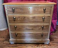 Front view of the Drexel nightstand showing three full drawers with acorn drawer pulls and decorative keyhole.
