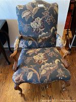 Front view of the tapestry and wood armchair showing overall condition and upholstery pattern