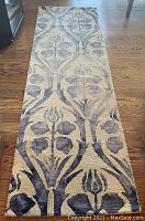 Full view of blue and off white Surya Serafina runner rug depicting floral pattern on hardwood floor.