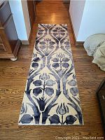 Full view of the runner rug on a hardwood floor showing the entire length and pattern.