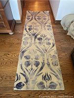 Full view of the runner rug placed on hardwood floor showing overall design and condition