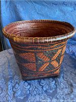 Single large round wicker basket with wide rim and dark geometric patterns