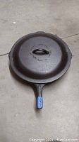 Top view of cast iron skillet with lid, showing lid handle and overall condition
