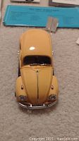 Top-down view showing the yellow 1967 Volkswagen Beetle diecast model with chrome detailing.