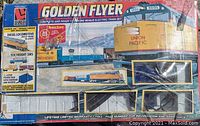 Golden Flyer boxed HO scale electric train set including diesel locomotive, freight cars, power pack, and instruction book.