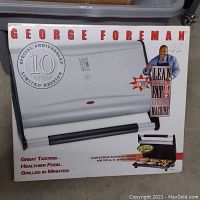Box front showing George Foreman 10th Anniversary Limited Edition Lean Mean Fat Grilling Machine with image of grill and grill handle, plus promotional text.