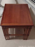 Top view of the smallest wooden nesting end table showing square beveled edge top and wood grain.