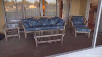 Full patio furniture set including couch, chair, coffee table, end table, and cushions, showing overall condition and arrangement.