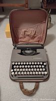 Front view of Smith Corona typewriter inside open carrying case, showing keyboard and logo.