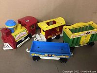 Full view of the Circus Train engine and three connected train cars, showing colors and condition.