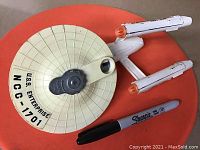 Top-down front angle view of the diecast Star Trek Enterprise model with Sharpie for size reference.