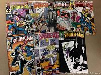 Seven issues of Peter Parker The Spectacular Spider-Man comics arranged on a surface with colorful covers featuring Spider-Man, Venom, and action scenes.