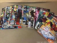 A full stacked lot of 35 Marvel superhero comics spread out and overlapping showing various colorful covers.