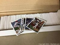 White box filled with over 850 Upper Deck baseball cards with some loose cards displayed on top showing player action shots.