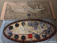 Full view of the sealed Millennium Coin Set with twelve coins displayed over a Canada map design dated 1999 in an oval box.