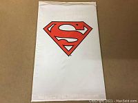 Front view of sealed collector's set with large red Superman logo on white polybag.