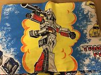 Close-up of vintage Transformers sheet showing robot character with vibrant colors.