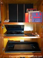 Overall view of three shelves showing two black panels, vinyl covers on top shelf, turntable on middle, BeoCenter 9500 on bottom.