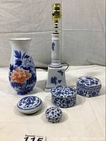 Photo showing all six items together: lamp, tall vase, and four small porcelain boxes.
