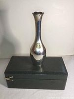 Front view of silver bud vase on presentation box