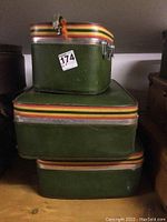 Luggage pieces stacked together showing green vinyl with striped trim.