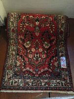 Full view of the oriental runner rug showing detailed floral and geometric patterns in reds and cream.