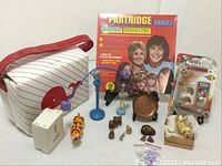 Lot overview showing all items including the insulated whale bag, Partridge Family album, Scoot Board toy, and various figurines and collectibles arranged on a white surface.