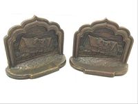 Pair of cast metal bookends depicting Shakespeare's house, showing the front reliefs and general shape.