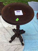 Full view of the round table top and pedestal base on white and blue cloth background.