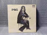 Front cover of Pag album by Johnny Pag showing seated man with long hair in black jacket and bell-bottom pants.