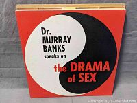 Front view of vinyl record cover titled 'Dr. Murray Banks speaks on the Drama of Sex' with a red, black, and white design