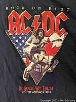 Front of AC/DC Rock or Bust tour XL T-shirt with graphic of guitarist jumping on American and Canadian flags background and large AC/DC logo