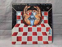 Front cover of George Duke's 'Master of the Game' vinyl album showing colorful artistic design with hands, figure and checkered floor.