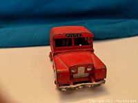 Front view of the red Mersey Tunnel Police toy truck showing the police label on the windshield and wear to the paint on the bumper.