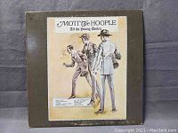 Front cover of the vinyl album 'All the Young Dudes' by Mott The Hoople showing illustrated artwork of three men in suits.