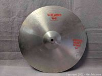 Full top view of the Meinl Streamer 14 inch bottom heavy hi-hat cymbal showing printed text and central mounting hole.