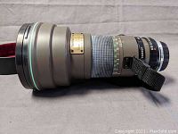 Side view of lens with tripod collar and strap attached