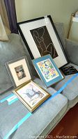 All four framed artworks arranged on a couch