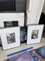 Four framed photographs displayed against a wall, including Il Siena street scenes and black and white prints.