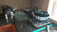 Photo showing cake pans, loaf pans, glass baking dishes, cooling racks, salt and pepper shakers on countertop.
